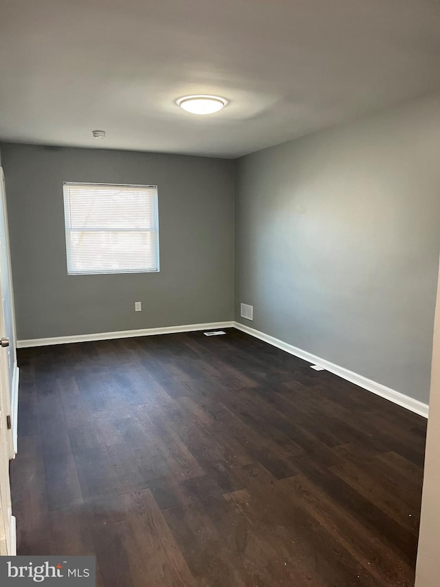 unfurnished room with dark hardwood / wood-style flooring