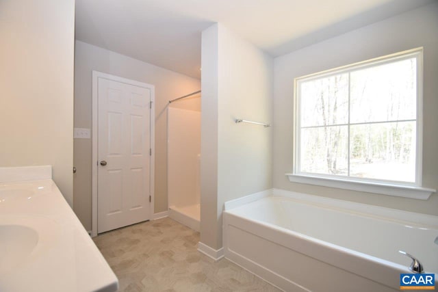 bathroom featuring shower with separate bathtub and sink