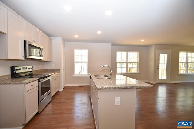 kitchen with white cabinetry, sink, stainless steel appliances, and a center island with sink