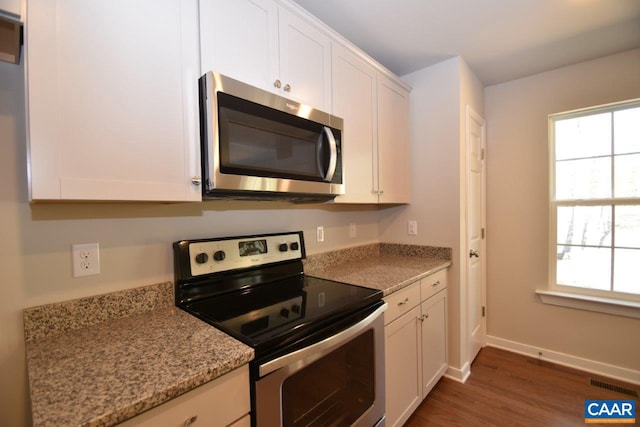 kitchen with white cabinetry, light stone counters, a wealth of natural light, and stainless steel appliances