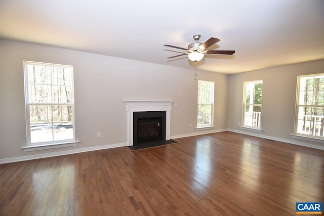 unfurnished living room with dark hardwood / wood-style flooring and ceiling fan