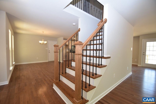 stairs with an inviting chandelier and wood-type flooring