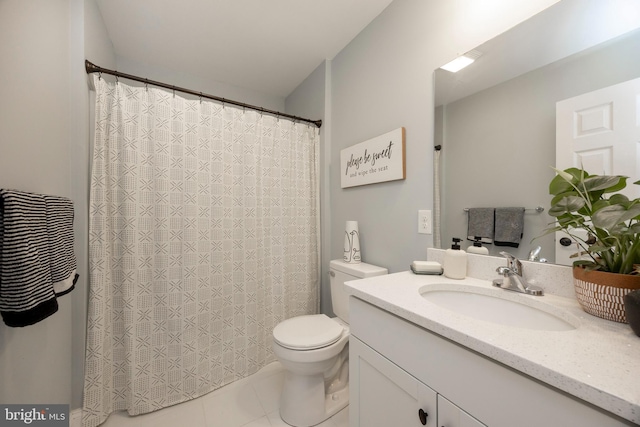 bathroom with toilet, vanity, and tile patterned flooring