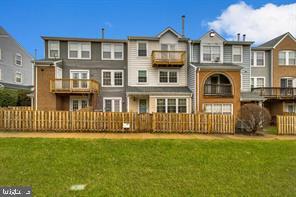 rear view of property featuring fence and a yard