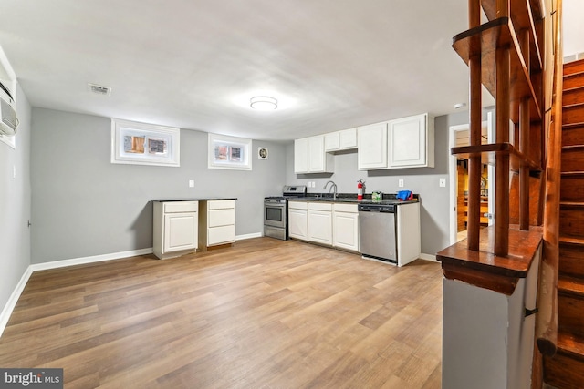 kitchen with light wood-type flooring, stainless steel appliances, sink, and white cabinets