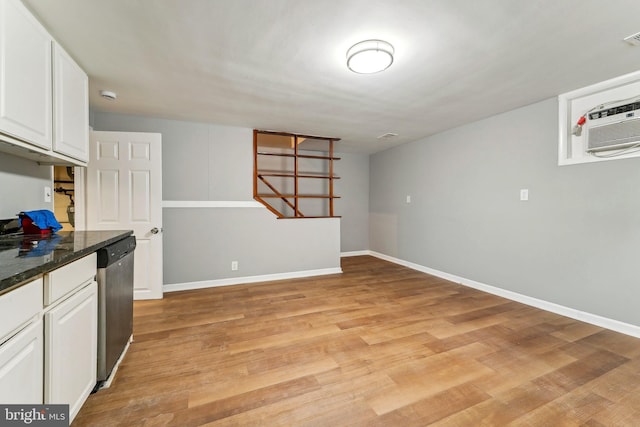 kitchen with dark stone counters, dishwasher, light wood-type flooring, and white cabinets