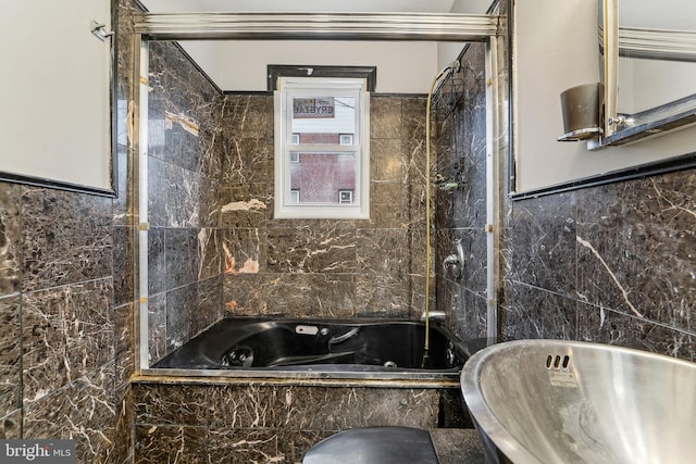 bathroom featuring tiled shower / bath combo and tile walls