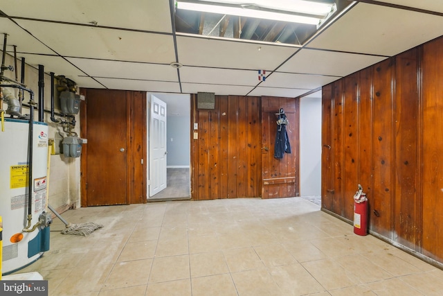 basement with water heater and wooden walls