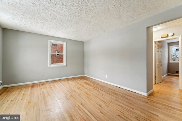 unfurnished room with light hardwood / wood-style floors and a textured ceiling