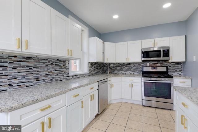 kitchen with white cabinetry, tasteful backsplash, light tile patterned flooring, and appliances with stainless steel finishes