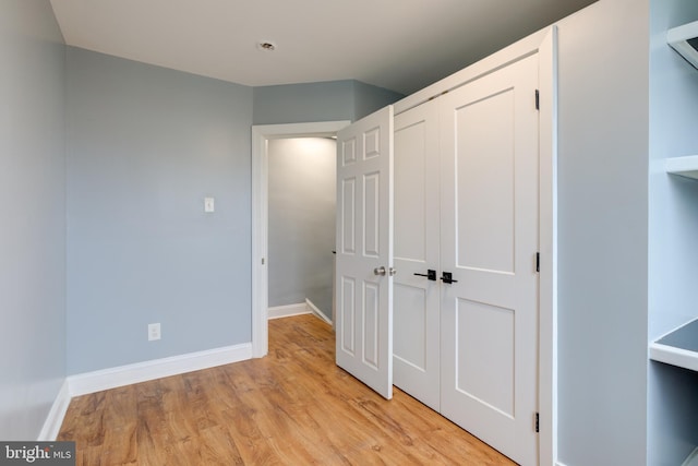 unfurnished bedroom with a closet and light wood-type flooring