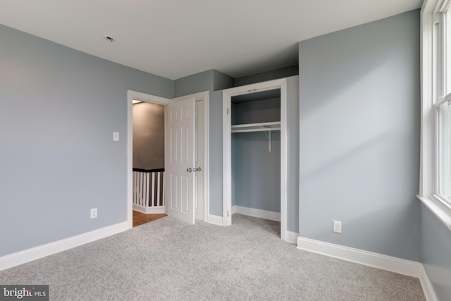 unfurnished bedroom featuring light carpet and a closet