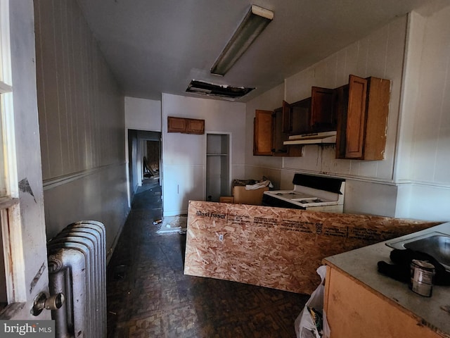 kitchen featuring radiator heating unit and white stove