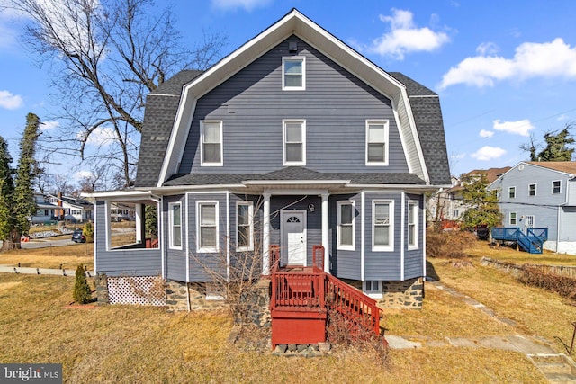 dutch colonial with a shingled roof, a front yard, and a gambrel roof