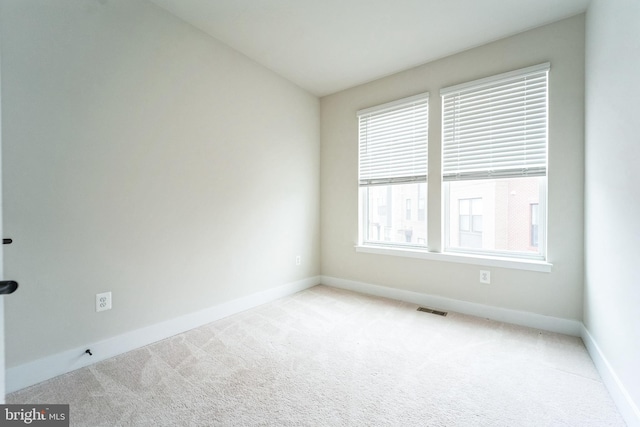 carpeted empty room with visible vents and baseboards