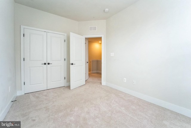 unfurnished bedroom with a closet, visible vents, baseboards, and carpet flooring