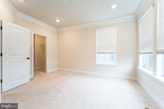 carpeted empty room with recessed lighting, crown molding, and baseboards