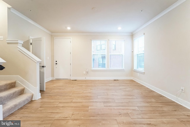 foyer featuring baseboards, light wood-style flooring, stairway, and crown molding