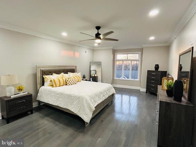 bedroom featuring dark hardwood / wood-style flooring, ornamental molding, and ceiling fan