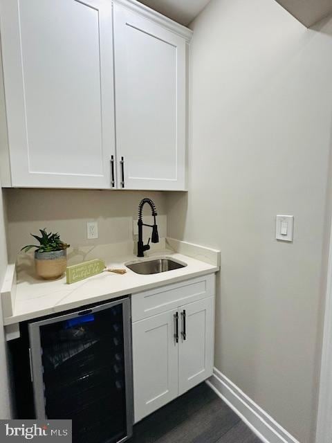 bar featuring white cabinets, sink, dark wood-type flooring, and wine cooler