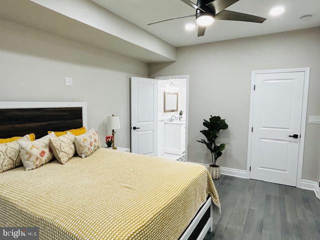 bedroom featuring ensuite bathroom, dark wood-type flooring, and ceiling fan