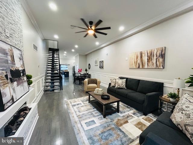 living room featuring crown molding, hardwood / wood-style floors, and ceiling fan