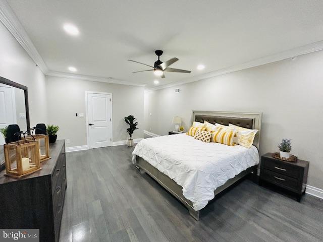 bedroom featuring dark wood-type flooring, ornamental molding, and ceiling fan