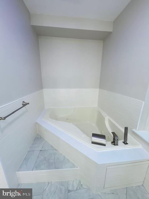 bathroom featuring tiled tub