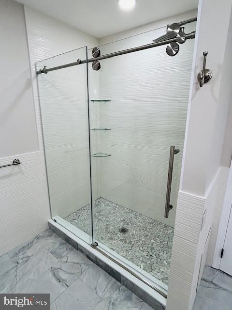 bathroom featuring a tile shower and tile walls