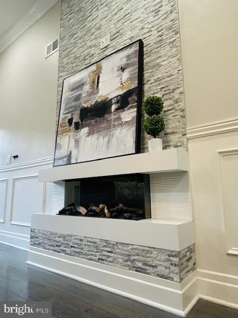 interior details featuring crown molding and a multi sided fireplace