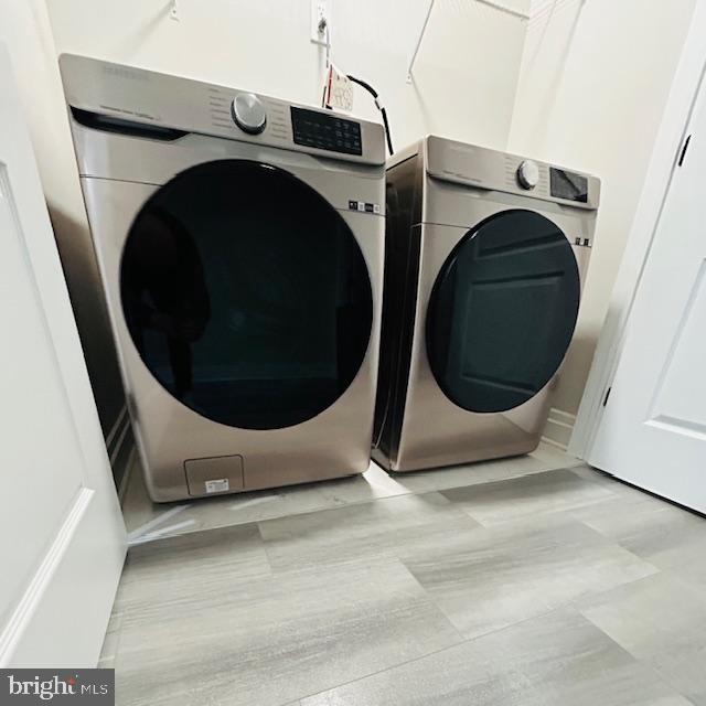 clothes washing area featuring separate washer and dryer