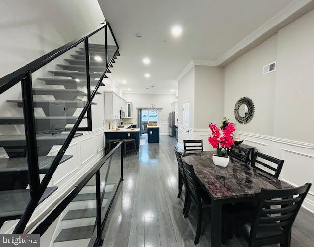 dining room featuring dark hardwood / wood-style flooring and crown molding