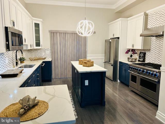 kitchen with high quality appliances, white cabinetry, a center island, and pendant lighting