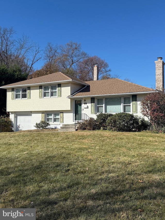 split level home with a garage and a front lawn