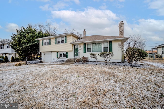 split level home featuring a garage and a chimney