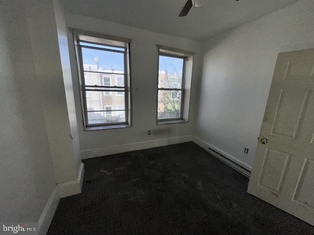 spare room featuring ceiling fan and baseboard heating