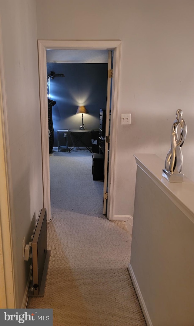 corridor featuring baseboards and light colored carpet