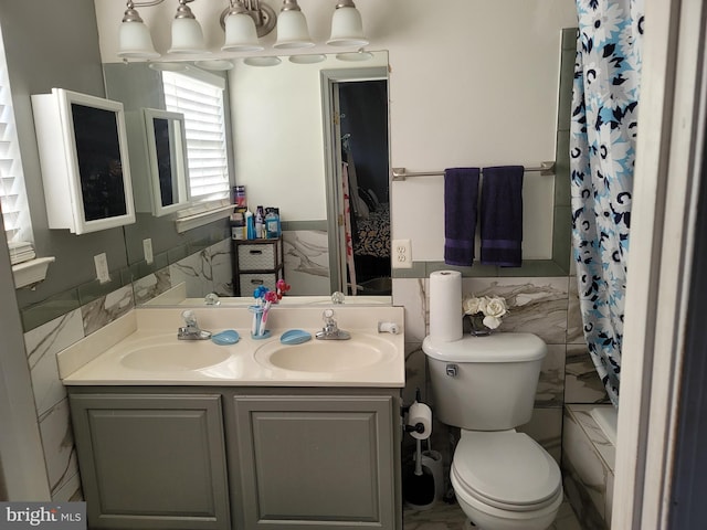 bathroom with wainscoting, toilet, tile walls, and vanity