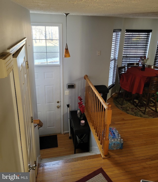 foyer entrance featuring a textured ceiling and wood finished floors