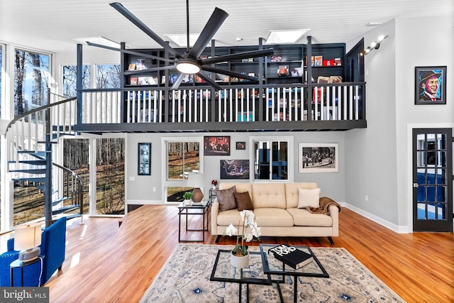 living room featuring baseboards, stairway, and wood finished floors