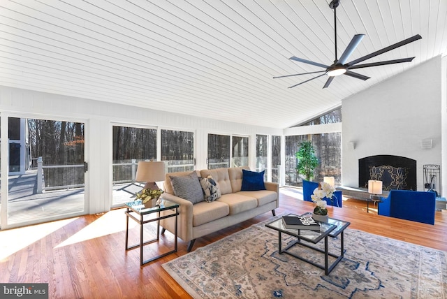 living room with lofted ceiling, a fireplace, and wood finished floors