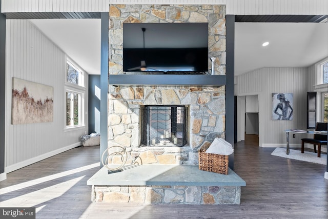 living room with a stone fireplace, baseboards, and wood finished floors