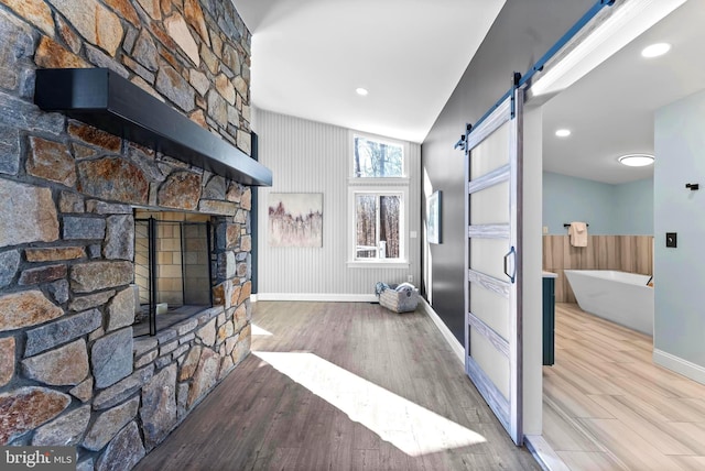 interior space featuring a barn door, wood finished floors, and baseboards