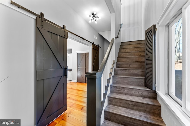 stairway with hardwood / wood-style flooring and a barn door