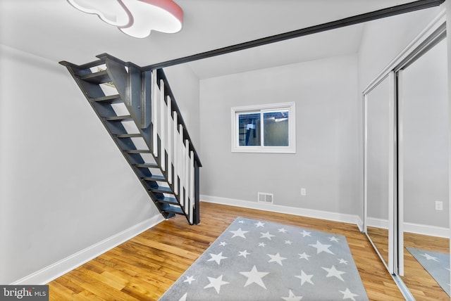 interior space featuring visible vents, stairway, baseboards, and wood finished floors