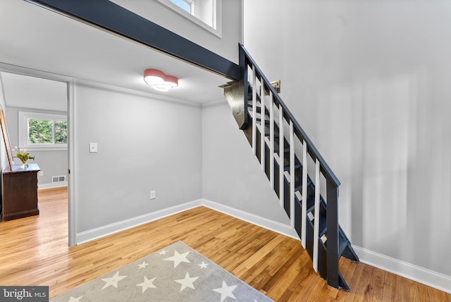 stairs with visible vents, baseboards, and wood finished floors