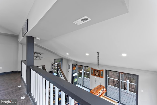 hallway with visible vents, lofted ceiling, wood finished floors, an upstairs landing, and recessed lighting