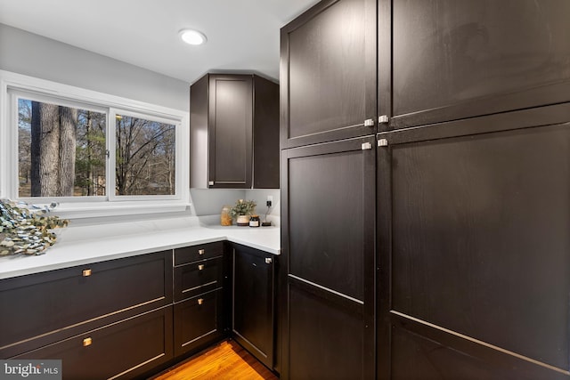 kitchen with recessed lighting, light countertops, light wood-style flooring, and dark brown cabinets