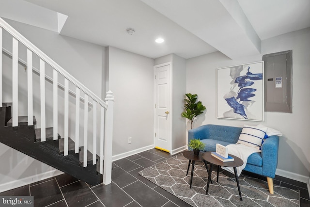 sitting room featuring dark tile patterned floors and electric panel