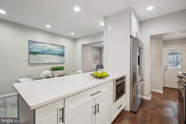 kitchen featuring kitchen peninsula, white cabinets, and stainless steel appliances